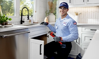 A Roto-Rooter technician services a garbage disposal in Dallas