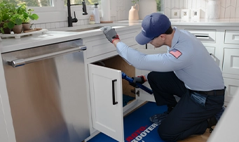 Roto-Rooter technician performing a repair on a garbage disposal in Dallas
