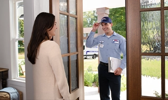 Woman opens the front door of her house to let in a Roto-Rooter technician