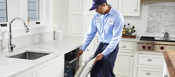 Roto-Rooter plumber examining broken dishwasher