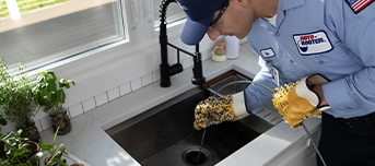 Roto-Rooter technciian snaking kitchen sink drain