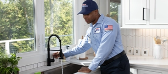 Roto-Rooter technician testing out faucet post-installation