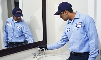 Plumber inspecting faucet in order to determine root of problem