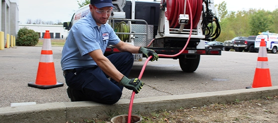 Technician jetting clogged sewer line