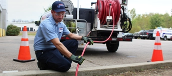 Technician jetting clogged sewer line