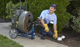 Smiling technician in process of repairing sewer line