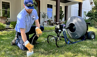 Plumber fixing sewer line using drain cleaning technology