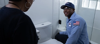 Technician informing client of toilet repair process prior to work commencing
