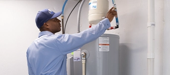 Roto-Rooter technician inspecting faulty water heater