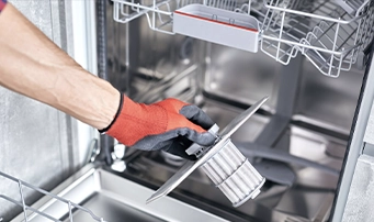 A technician checking a filter during a dishwasher installation in Minneapolis.