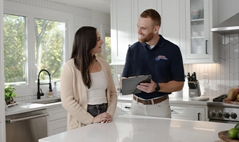 A Roto-Rooter technician in Minneapolis discusses repair financing options with a homeowner