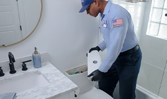A Roto-Rooter technician inspecting the tank for a toilet repair in Minneapolis.
