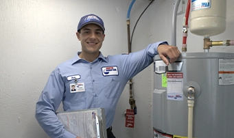 A Roto-Rooter technician smiles after completing a water heater repair in Minneapolis