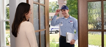 Female homeowner opens front door to a Roto-Rooter technician