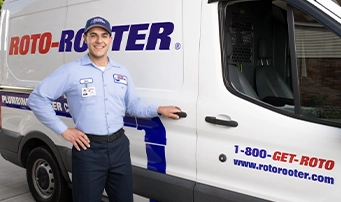 Roto-Rooter technician standing outside a Roto-Rooter van