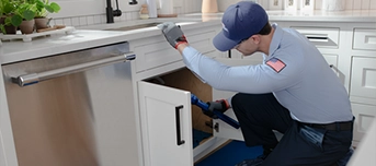 A Roto-Rooter technician inspecting a garbage disposal in Portland.