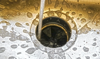 A person testing their garbage disposal in Portland with the faucet water running.