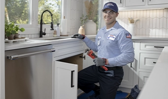 Roto-Rooter technician with wrench in hand performing leak repair in Portland