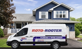 Roto-Rooter van parked outside a blue house
