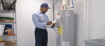 Roto-Rooter technician conducting a hot water heater repair in a Portland basement