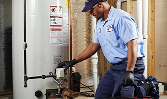 A Roto-Rooter technician inspects a water heater repair in Portland