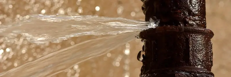 Worn pipe bursting open and leaking water in Denver