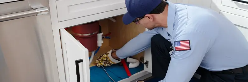 Roto-Rooter technician clearing out a congested garbage disposal in Seattle