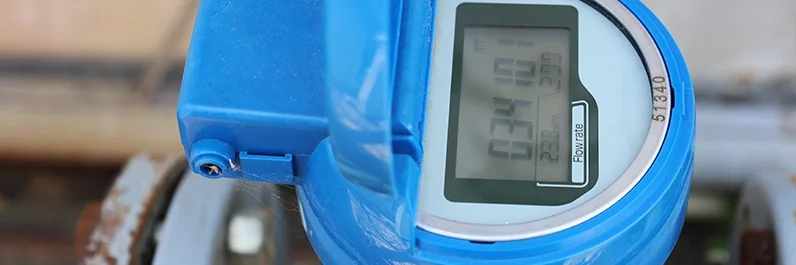 Close-up view of an electronic water meter in a backyard