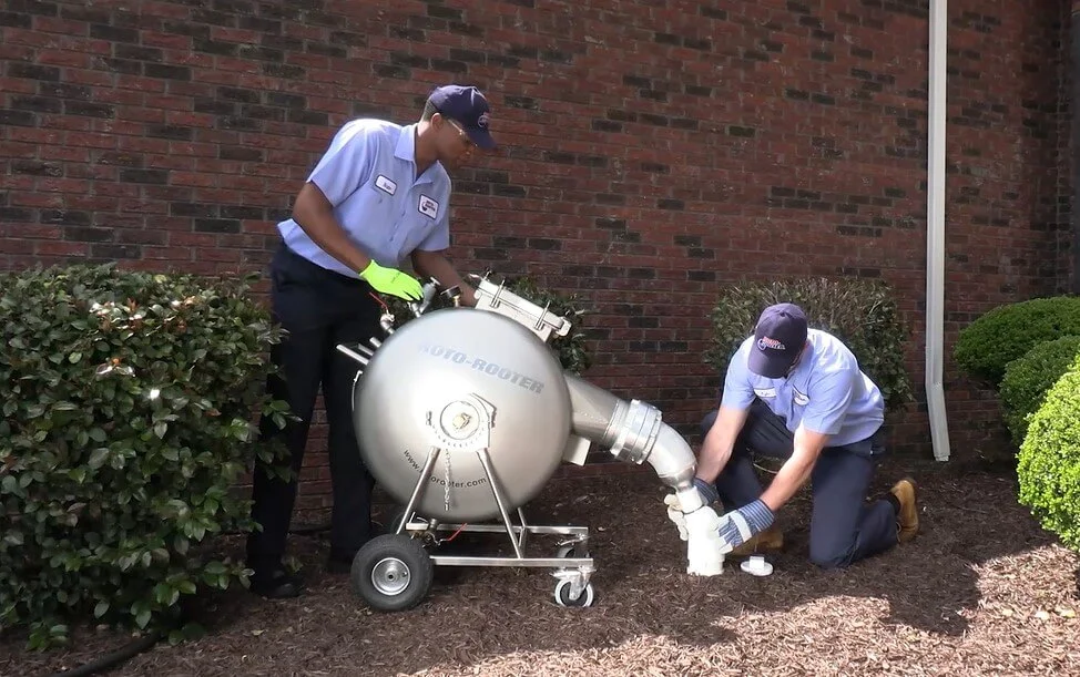 Two plumbers working together to perform Zero-Dig Trenchless Pipe Repair services on unseen underground pipes