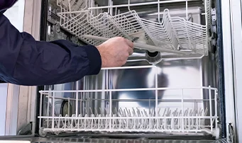 Plumber fixing dishwasher