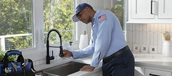 Roto-Rooter technician inspecting kitchen sink