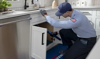 Roto-Rooter plumber looking at garbage disposal