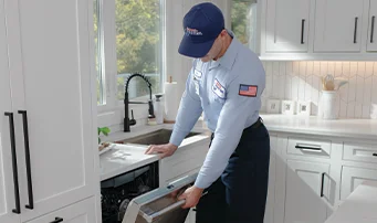 Technician inspects leak in dishwasher