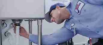 Plumbing technician inspecting drain pipe