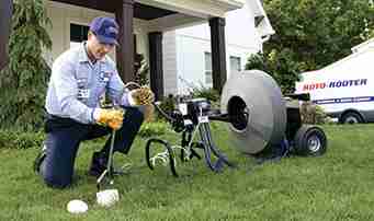 Plumer draining sewage from sewer line withy machine