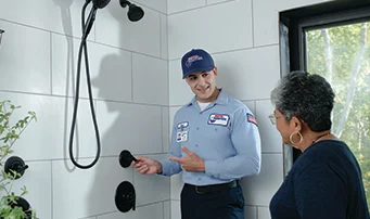 Technician guides client through work done to fix shower