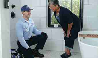 Plumber helps satisfied client to fix shower and bathtub