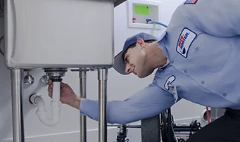 Plumbing technician inspecting drain pipe